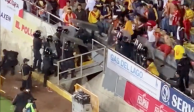 Momento exacto en el que aficionados del Atlético Morelia avientan objetos y agarran a golpes a policías en el Estadio Morelos.