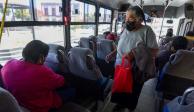 COVID-19: Una mujer en autobús se protege del coronavirus, en su mano lleva una bolsa roja