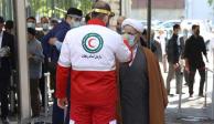 Funcionarios de salud controlan la temperatura corporal de lfieles durante la primera oración del viernes en Teherán, Irán