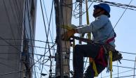 Un trabajadores de la CFE realizan labores en un poste de luz. Este martes,la Embajada de EU en México cuestionó la reforma eléctrica que plantea AMLO