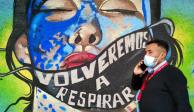 COVID-19: Una persona camina frente a un mural con el mensaje "Volveremos a respirar"