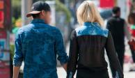 Una pareja camina tomada de la mano por la calle