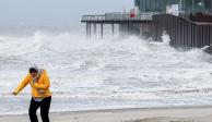Una persona camina mientras las olas azotan la playa tras la tormenta Eunice en Blankenberge, Bélgica.