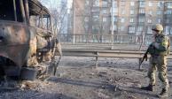 Un soldado ucraniano camina frente a un vehículo militar quemado, el sábado 26 de febrero de 2022, en Kiev, Ucrania