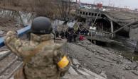 Residentes locales cruzan un puente destruido mientras evacúan la ciudad de Irpin, luego de fuertes bombardeos en la única ruta de escape utilizada por los lugareños, cerca de Kiev, Ucrania.