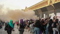 Encapuchadas con mazos tratan de derribar el cerco que rodea a Palacio Nacional, ayer.