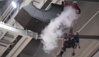 Bomberos utilizan un extintor de incendios en un grupo de altavoces que cuelgan del techo de la Scotiabank Arena, donde los Raptors juegan sus partidos como locales en la NBA.