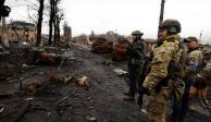 Soldados ucranianos observan vehículos militares rusos destruidos en Bucha, en la región de Kiev