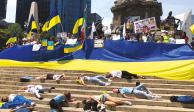 Manifestantes, durante la simulación de los muertos ucranianos, ayer, en el Ángel de la Independencia, en la CDMX.