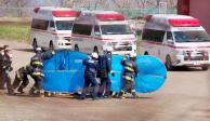Bomberos cubren con escudos a una persona a la que trasladan a un hospital después de ser rescatada en el mar en Shari, en la isla norteña de Hokkaido, el domingo 24 de abril de 2022
