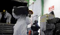 Trabajadores descargan sacos que contienen paquetes de cocaína de un camión antes de la incinerarlos en Ecuador el 21 de abril de 2022