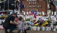Un hombre y un niño visitaron el monumento instalado en la primaria Robb, en Uvalde, Texas, para honrar a las 21 víctimas del tiroteo.