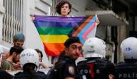 Manifestante con la bandera LGBT+ cerca de la policía turca antidisturbios que impide el Pride en Estambul.