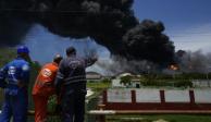 Trabajadores de CUPET observan una columna de humo que se eleva desde la Base de Superpetroleros de Matanzas, Cuba.