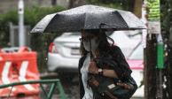 Una mujer camina protegiéndose de la lluvia con un paraguas