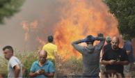 Ciudadanos se alejan de un incendio forestal en Añón de Moncayo, en Zaragoza, España.