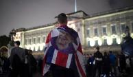 Un joven porta una bandera del Reino Unido con la cara de la reina Isabel II, tras su fallecimiento este jueves.