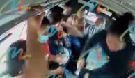 La imagen muestra el momento en que dos mujeres en Ecatepec asaltan a los pasajeros de una unidad de transporte público