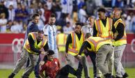 Lionel Messi observa al aficionado que fue derribado por la policía al final del partido amistoso entre Argentina y Jamaica.