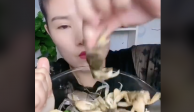 La mujer muestra un tazón lleno de cangrejos vivos