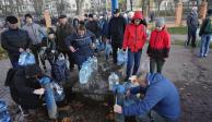 Ucranianos hacen fila en pozos para llevar un poco de agua a sus casas, ayer.