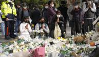 Ciudadanos y deudos oran frente a un memorial dedicado a las víctimas de la tragedia de Itaewon, ayer.