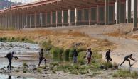 Un grupo de migrantes cruza corriendo el Río Bravo para ingresar a Estados Unidos