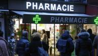 Personas esperan frente a una farmacia para hacerse una prueba de COVID-19 en París, Francia, el domingo 9 de enero de 2022