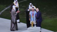 El Emir de Qatar Sheikh Tamim bin Hamad Al Thani le coloca un bsht a Lionel Messi.