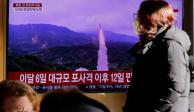 Una mujer pasa frente a un televisor que transmite un informe de noticias sobre Corea del Norte disparando un misil balístico frente a su costa este, en Seúl, Corea del Sur, el 18 de diciembre de 2022