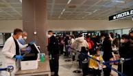 Pasajeros que llegan de China esperan en fila para la aplicación o revisión de las pruebas Covid, ayer, en un aeropuerto de Italia.