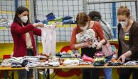 Voluntarios organizan ropa donada para personas ucranianas que viven asediadas por la guerra