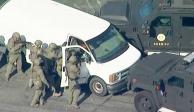 La policía usa vehículos blindados para rodear una camioneta de carga blanca en un estacionamiento en Torrance