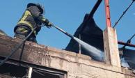 Un bombero combate con agua las llamas de un incendio en la colonia Ajusco de Coyoacán