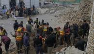 Agentes de seguridad y rescatistas buscan cuerpos en el lugar de un ataque suicida en Peshawar, Pakistán.