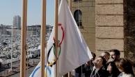 El alcalde de Marsella, Benoit Payan, eleva la bandera olímpica frente al director de París 2024, Tony Estanguet.
