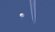 Un gran globo se desplaza por encima de la zona de Kingstown, Carolina del Norte, mientras por debajo se observa un avión y la estela que deja a su paso