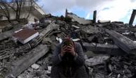 Un hombre llora sentado sobre los escombros de una casa en la ciudad de Nurdagi en el sur de Turquía.