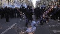 Policías antimotines en sus puestos mientras les lanzan proyectiles en una manifestación contra los planes de reformar el sistema de pensiones de Francia, en París, el sábado 11 de febrero de 2023. (AP Foto/Michel Euler)