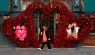 Mujer camina frente a un adorno de San Valentín, en Londres.