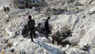 Habitantes buscan sobrevivientes bajo los escombros de uno de  los edificios dañados en la ciudad rebelde de Harem, Siria, ayer.