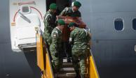 Soldados bajan a Proteo del avión militar que llegó de Turquía, ayer, en la base militar de Santa Lucía, en el AIFA.