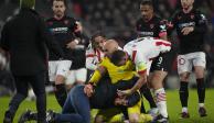 Jugadores intervienen después de que un aficionado del PSV atacó al portero del Sevilla Marko Dmitrovic en el encuentro de la Europa League