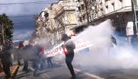 Un manifestante acciona un extintor contra un grupo de policías en las calles de Atenas, ayer.