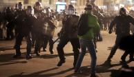 Policías con escudos enfrentan a manifestantes en calles de París, ayer.