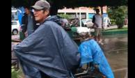 Hombre coloca bolsa a 'lomito' para que no se moje con la lluvia