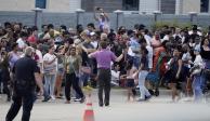 Personas se reúnen del otro lado de la calle de un centro comercial tras un tiroteo el sábado 6 de mayo de 2023 en Allen, Texas
