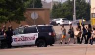 Gente con las manos en alto a la salida de un centro comercial tras reportes de un tiroteo el sábado 6 de mayo de 2023 en Allen, Texas.