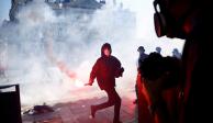 Un manifestante sostiene una bengala roja durante los enfrentamientos en Nantes, ayer.