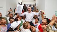 Manolo Jiménez (centro) celebra mientras sostiene la constancia que le entregó el Instituto Electoral de Coahuila.